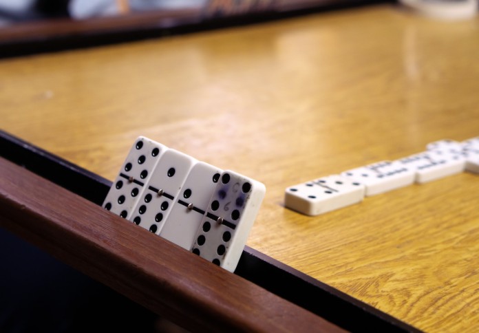 Una mesa de dominó con fichas, uno de los deportes de mesa.